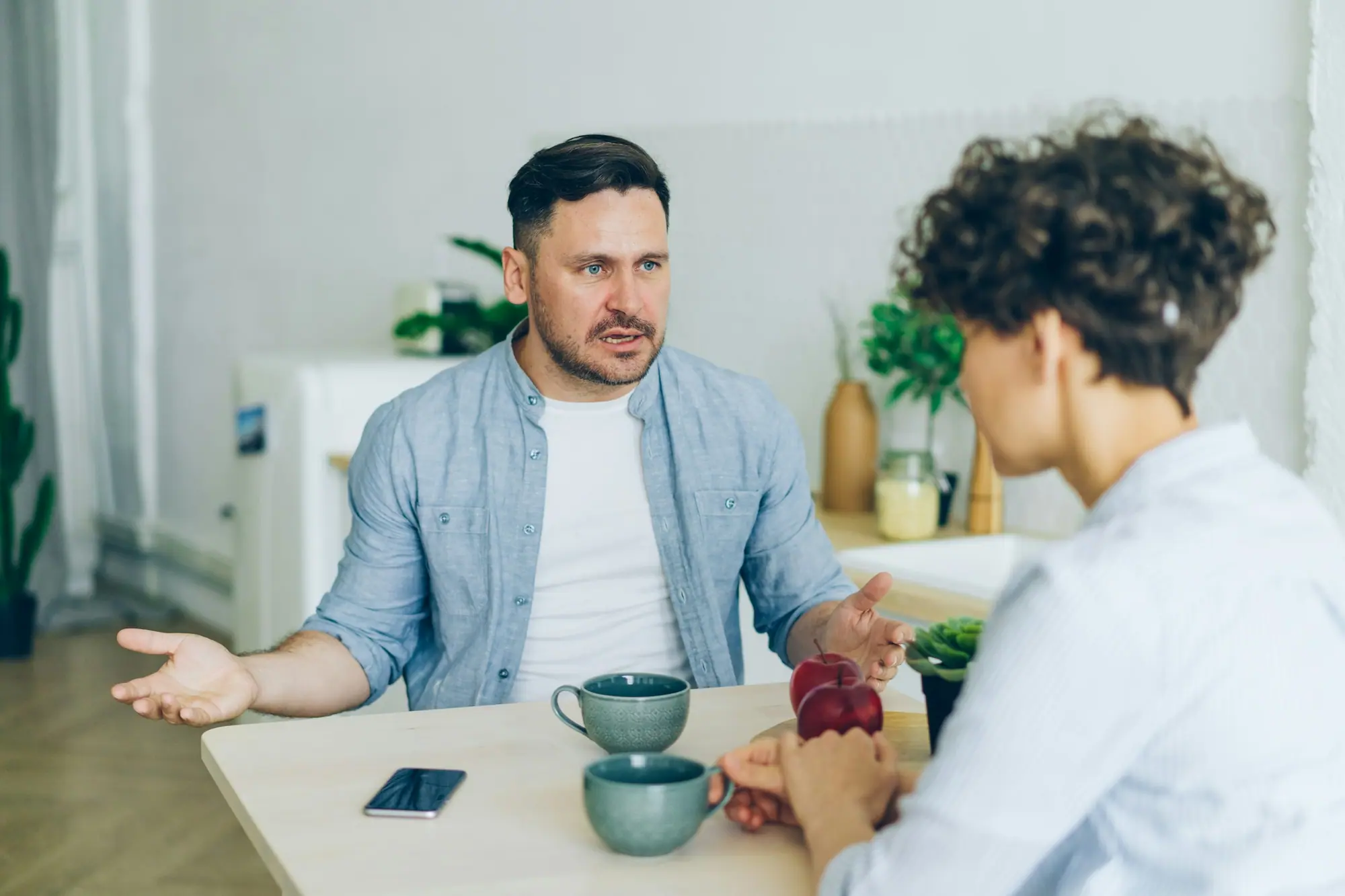 A husband and wife talking things through at the kitchen table