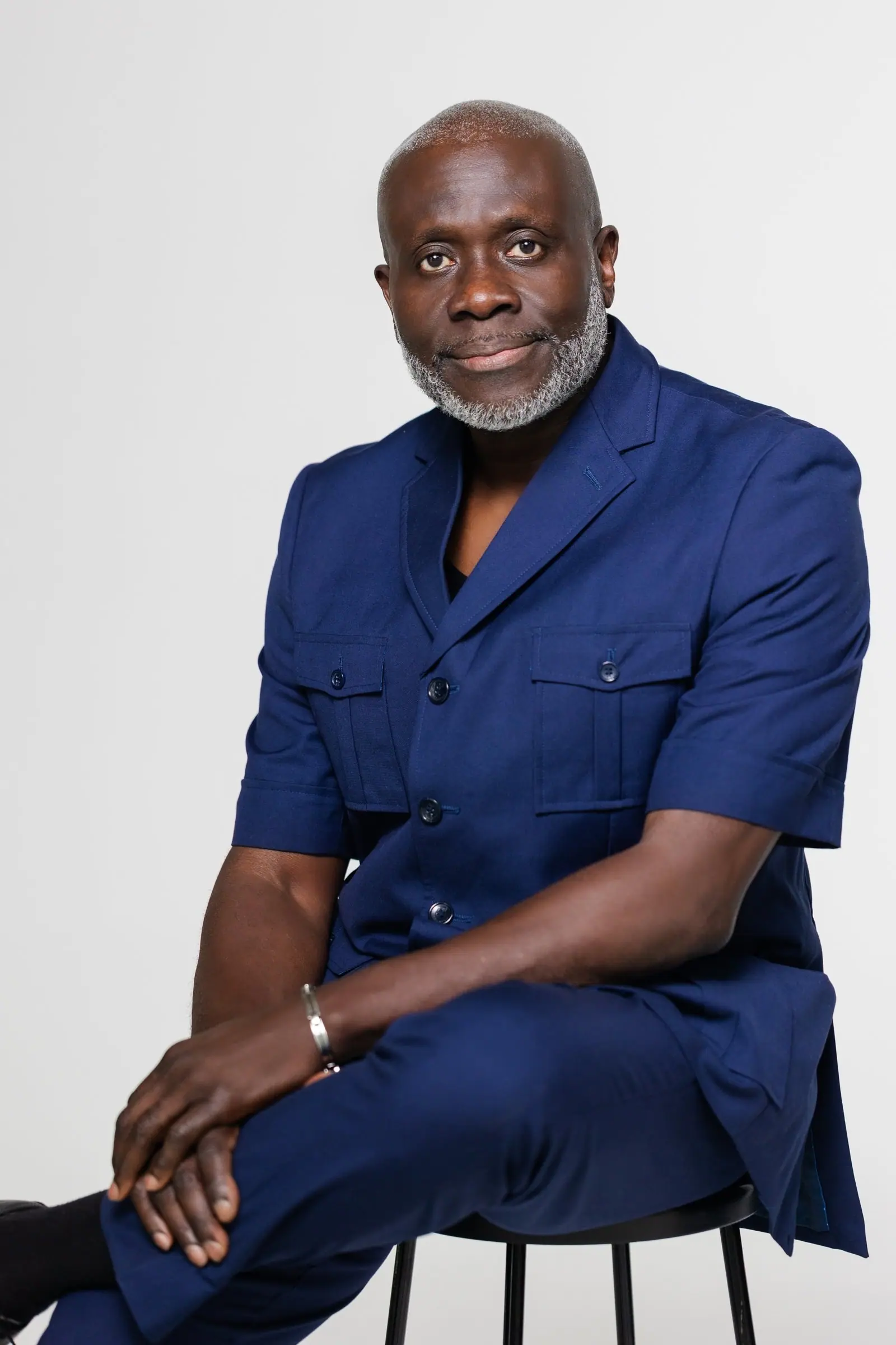 Pastor Victor in a navy suit, seated and smiling